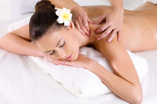 Woman in beauty salon having massage of shoulder   - horizontal