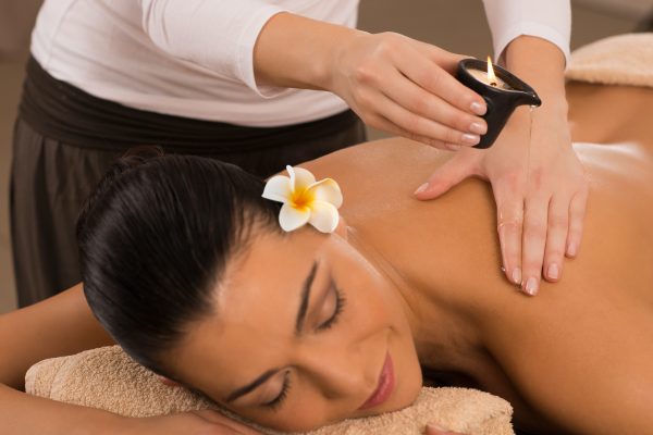 Relaxed Woman Receiving A Candle Massage