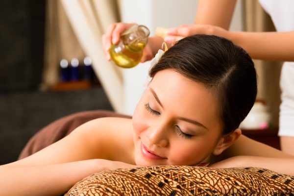 Chinese Asian woman in wellness beauty spa having aroma therapy massage with essential oil, looking relaxed
