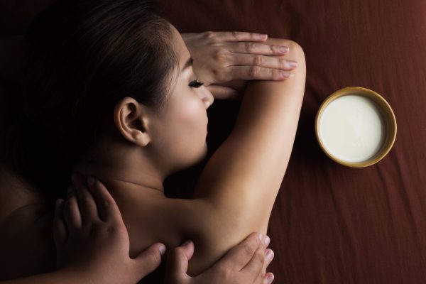 Asian woman having massage and bowl of milk , spa salon Beauty treatment